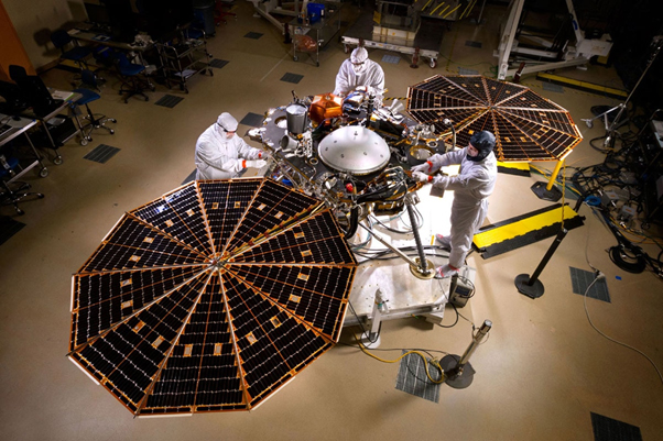 Scientists work on the real-life contents of InSight, including its solar-panel arrays. (Source: NASA/JPL-Caltech/Lockheed Martin)
